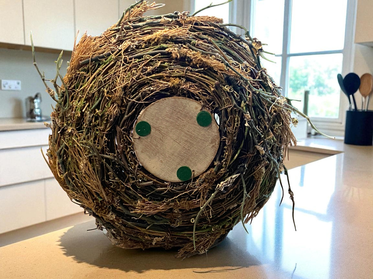 Decorative bird nest with a face on a kitchen counter