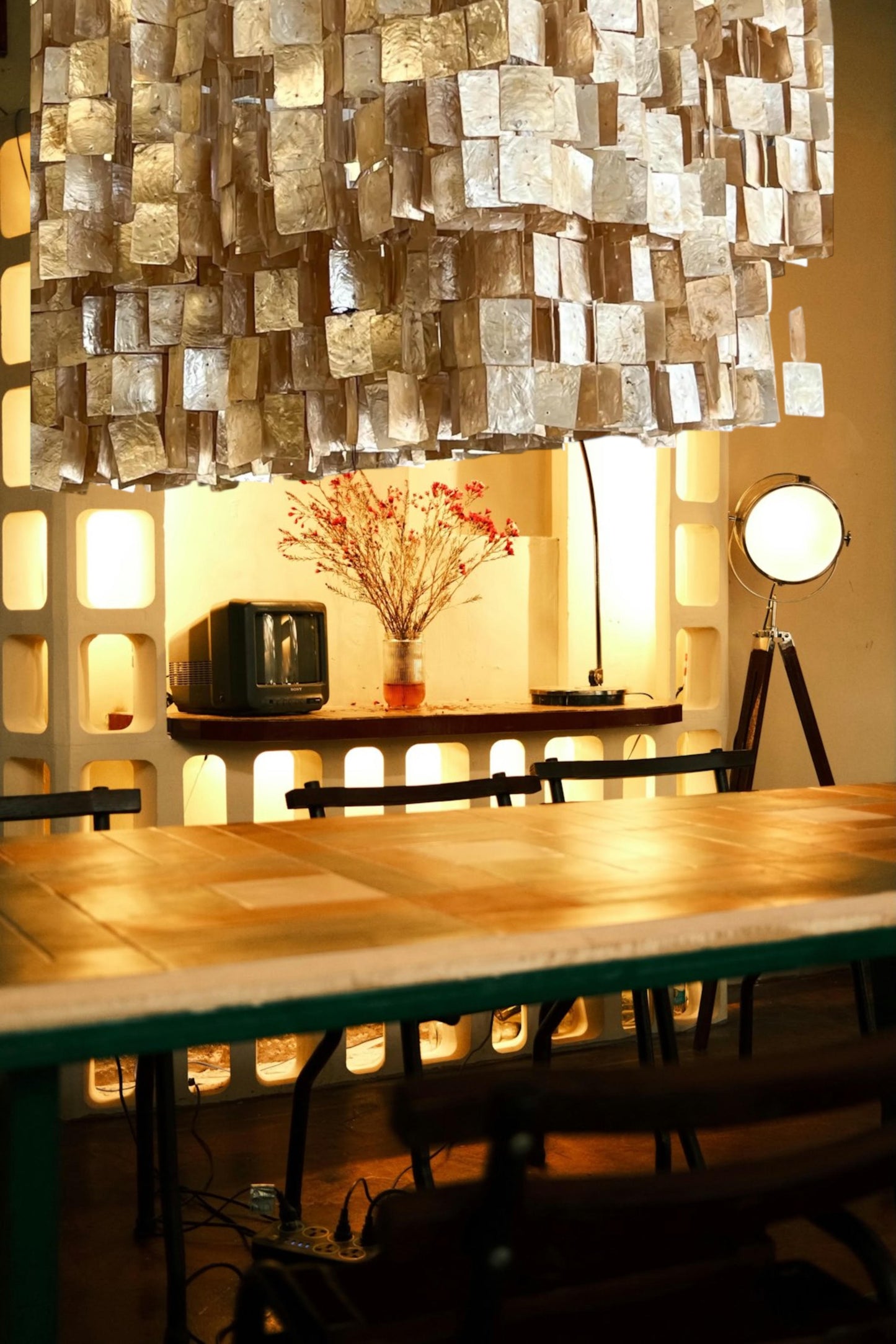 Dining area with a textured ceiling light fixture, wooden table, and decorative elements.