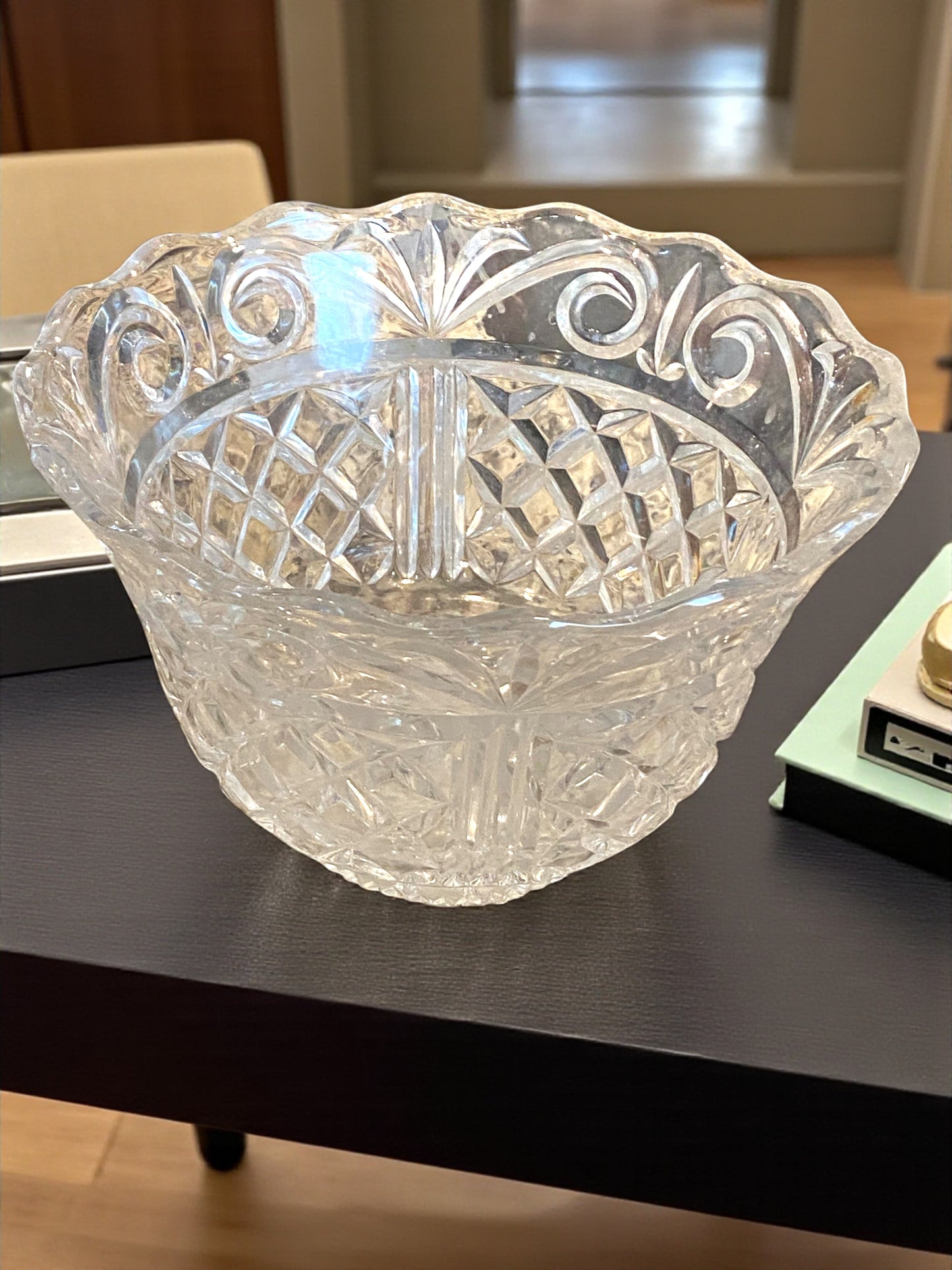 Clear glass bowl with intricate patterns on a dark surface