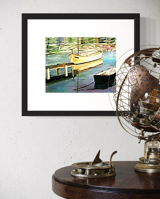 Framed artwork of boats on a dock with a decorative globe and compass on a table.