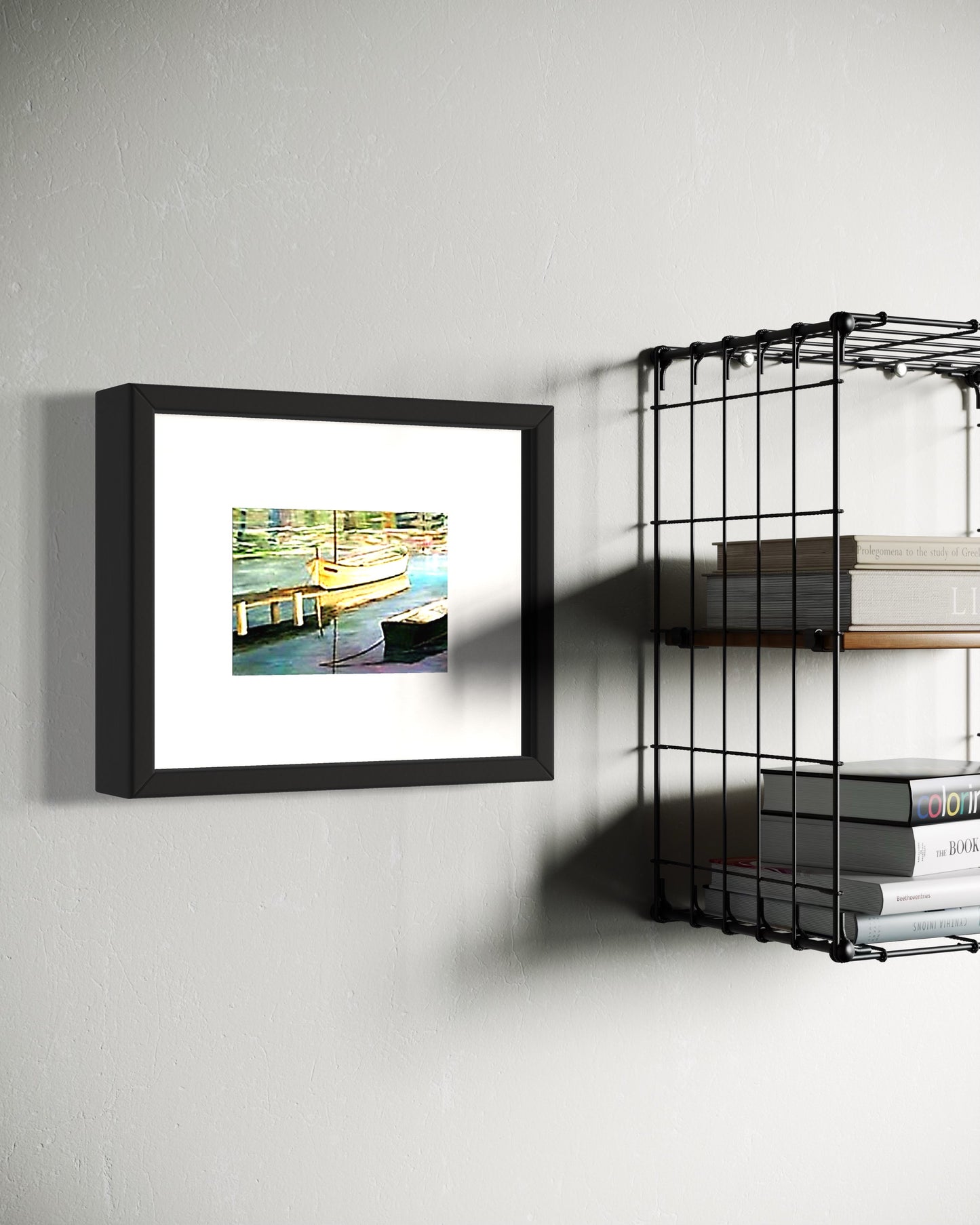 Framed artwork on a wall next to a metal shelf with books