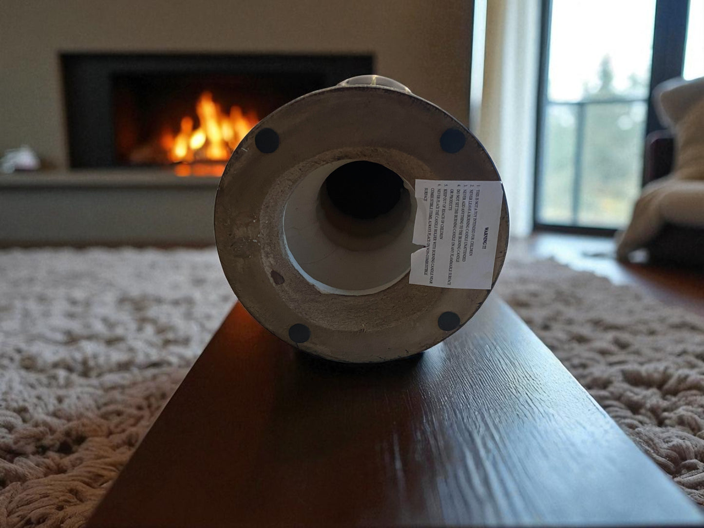 Spool of ribbon on a table with a fireplace and window in the background