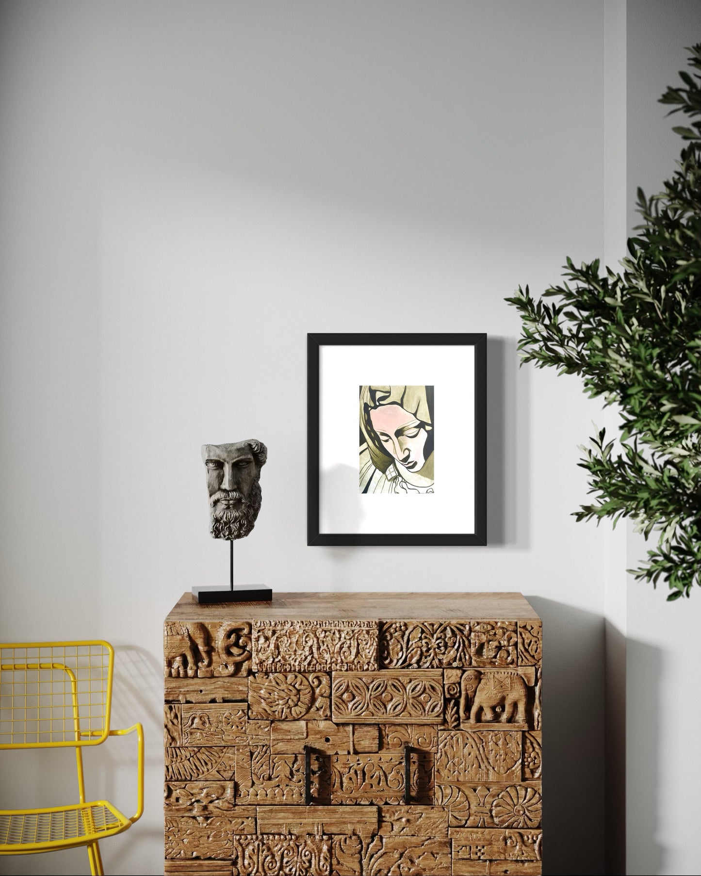 Decorative piece with a framed print, sculpture, and wooden cabinet against a white wall.