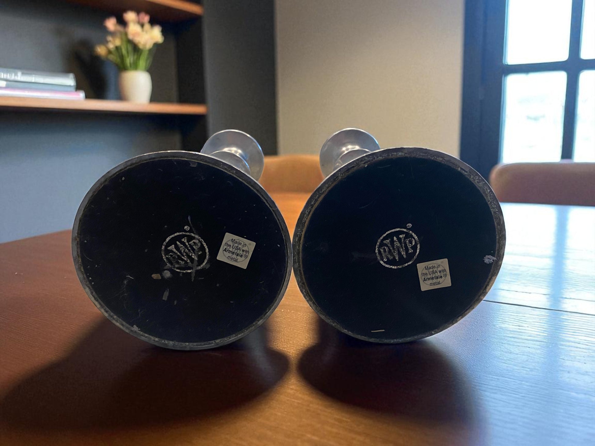 Two black cylindrical objects with visible branding on a wooden surface.