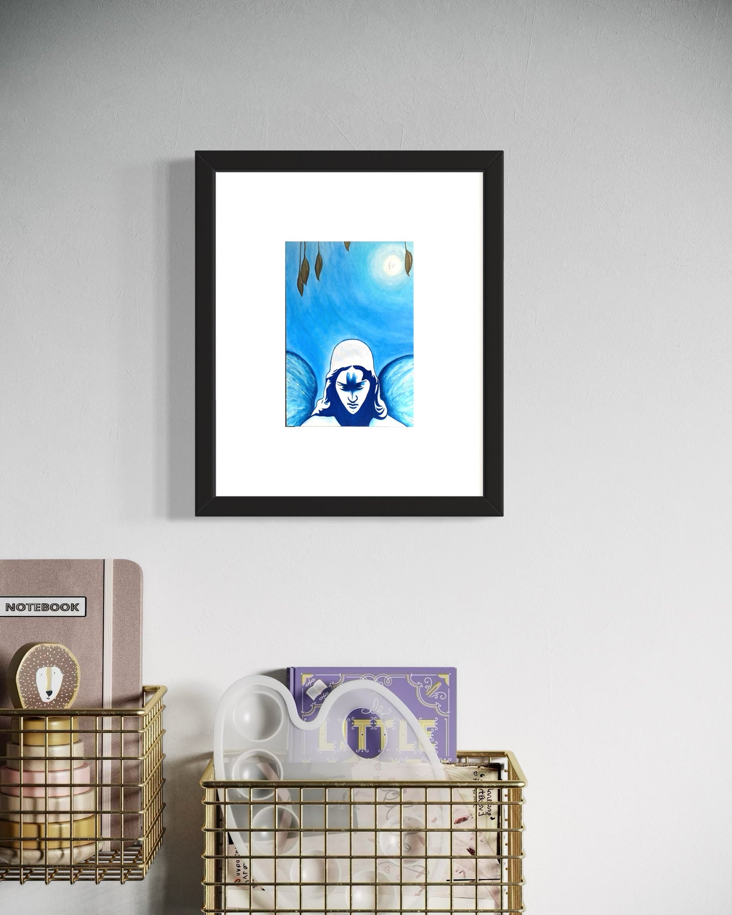 Framed artwork of a blue and white abstract design on a gray wall with decorative items below.