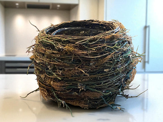 Artificial bird's nest on a countertop with a blurred background