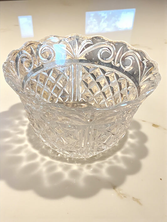 Clear glass bowl with intricate cut patterns on a light background