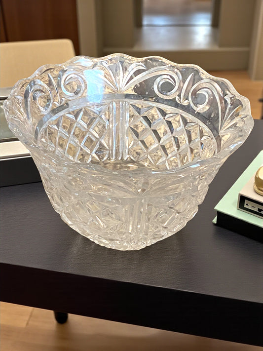 Clear glass bowl with intricate patterns on a dark surface