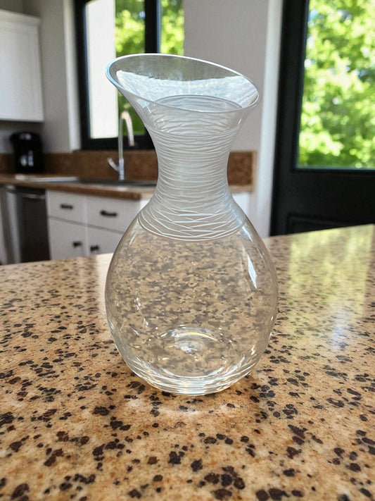 Clear glass carafe on a speckled countertop with kitchen background