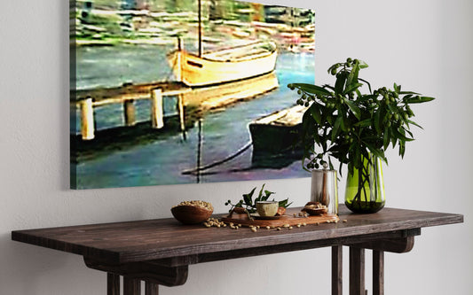Table with decorative items in front of a painting of a dock with boats.