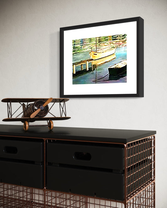 Framed artwork of a dock scene with boats on a wall above a black cabinet with a model airplane.