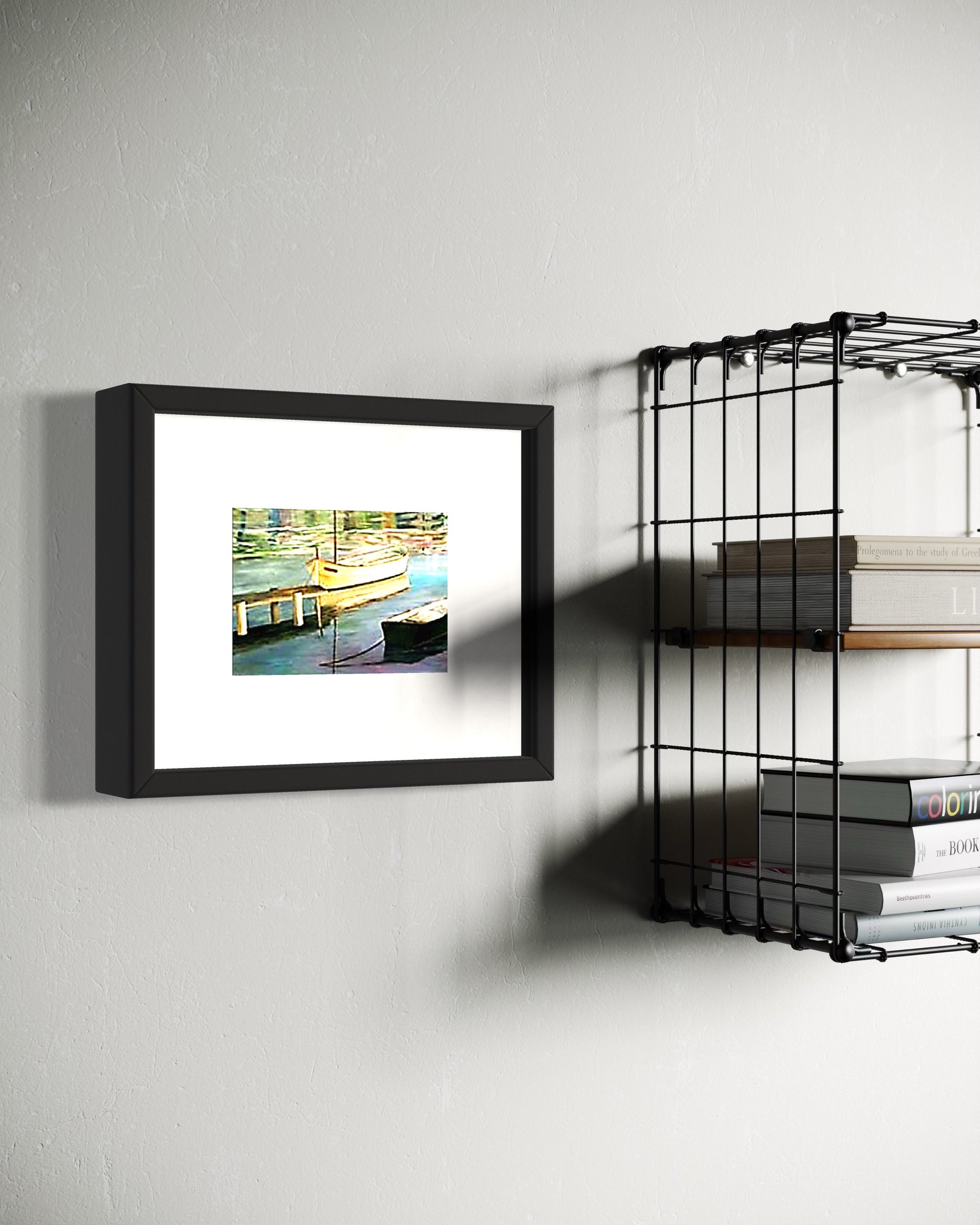 Framed artwork on a wall next to a metal shelf with books