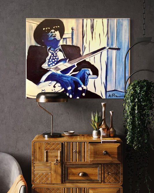 Framed artwork of a person playing guitar on a wall above a wooden cabinet.