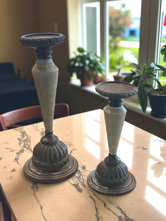 Two candle holders on a marble surface with a blurred indoor background