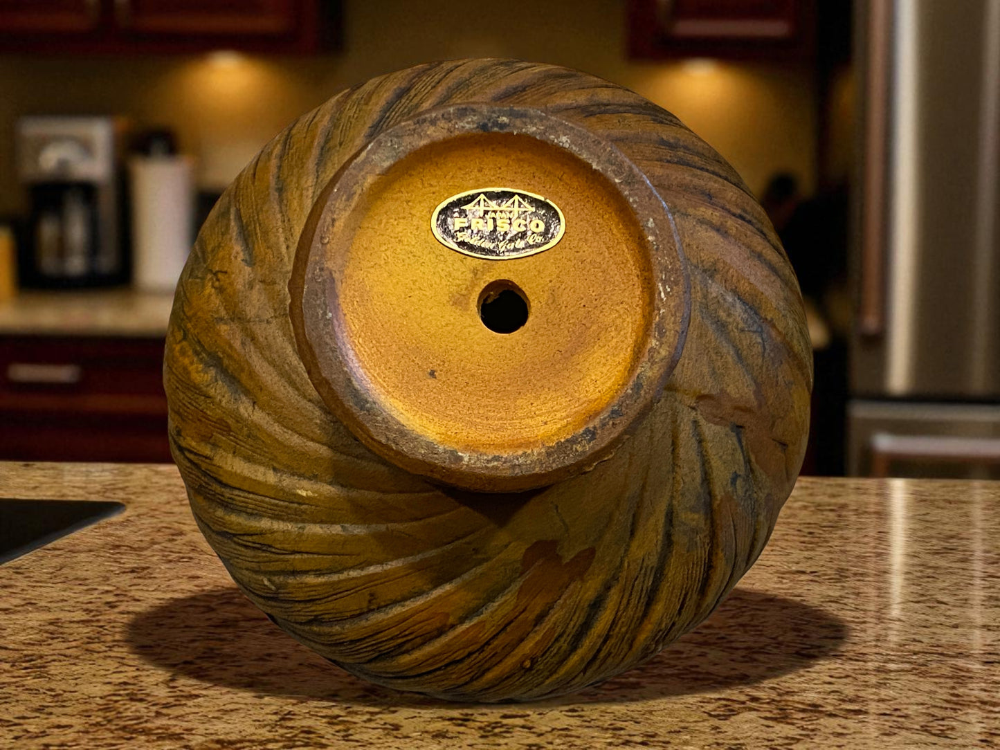 Decorative wooden bowl with a brand label on a kitchen counter