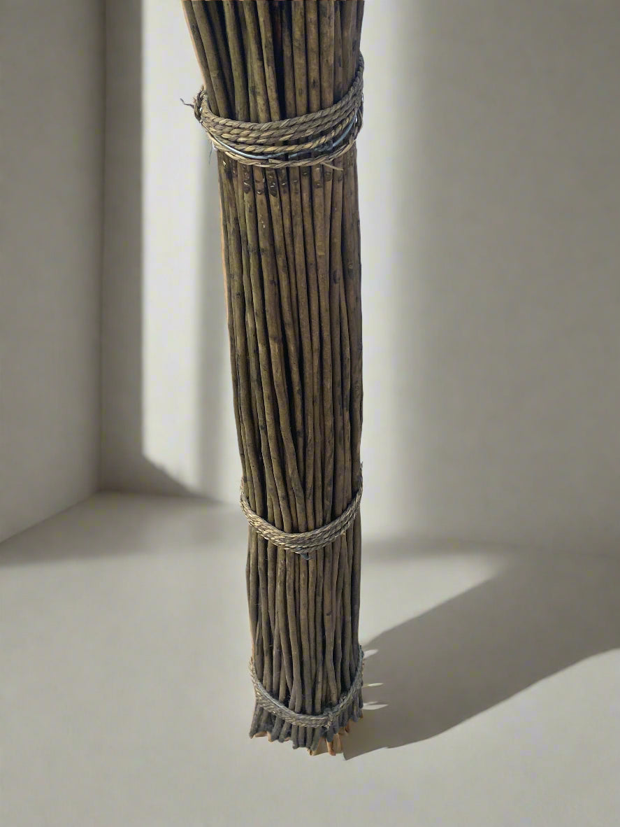 Wicker Sculpture tied together with twine against a neutral background